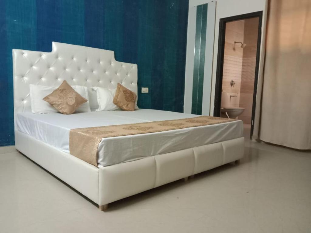 a bedroom with a large white bed with a headboard at City Palace in Zirakpur