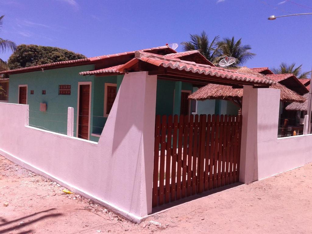 una casa con una puerta y una valla en Casa Verde Maragogi, en Maragogi