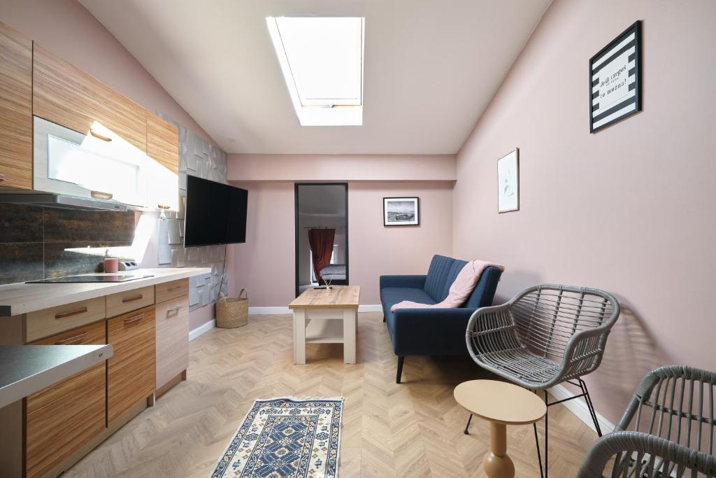 a kitchen and living room with a couch and a chair at Apartamenty Zlotoryja Silver in Złotoryja