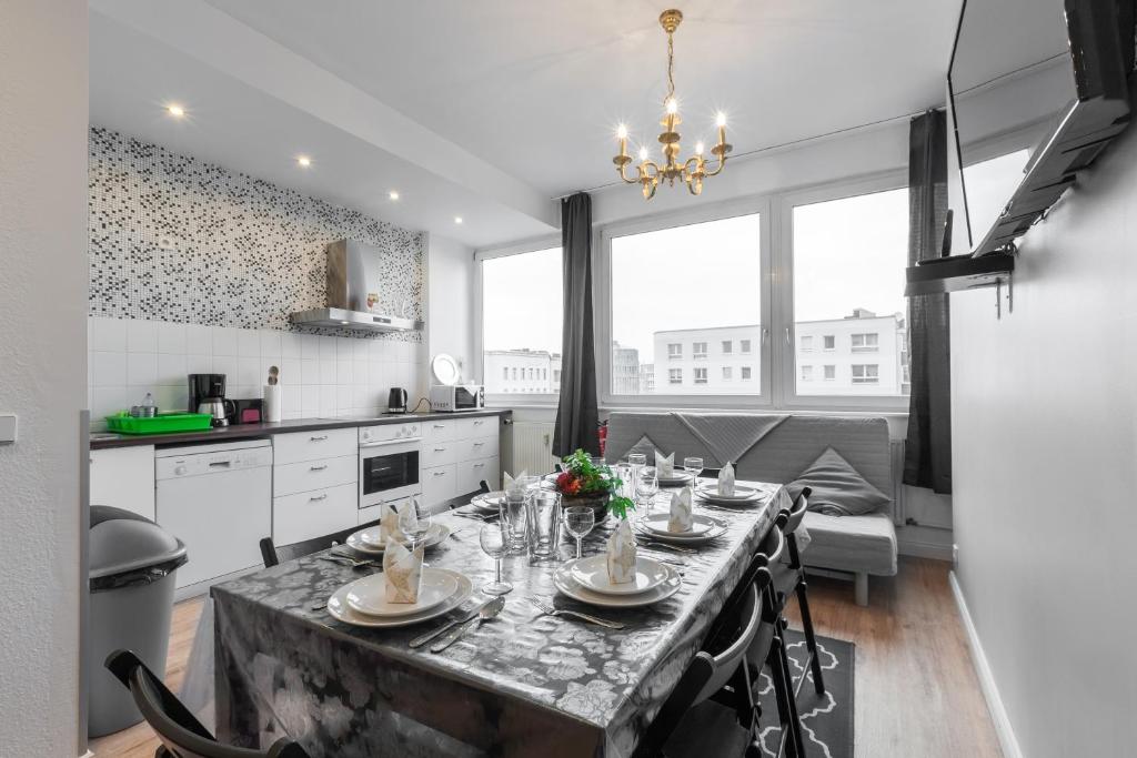 a kitchen with a table with chairs and a dining room at Trendy Apartments in Berlin
