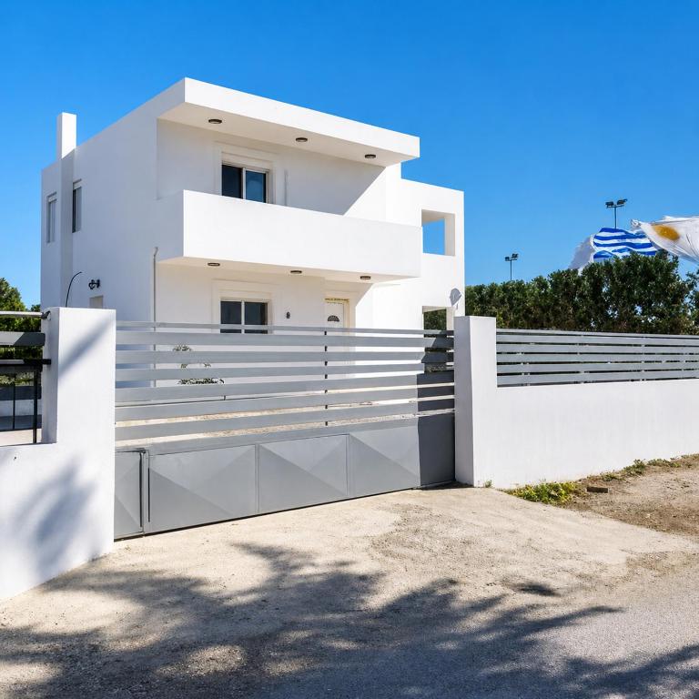 a white house with a fence in front of it at Gennadi Villa Mare 300m from the Beach in Gennadi