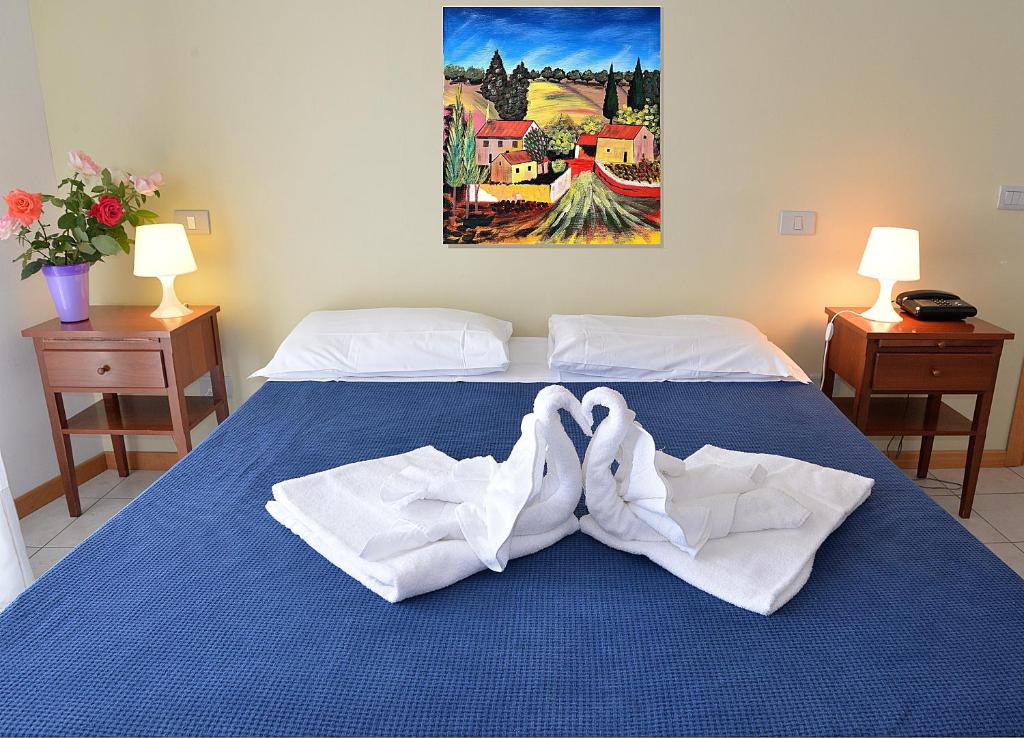 Una cama con dos pares de toallas. en Residence Le Corniole, en Arezzo