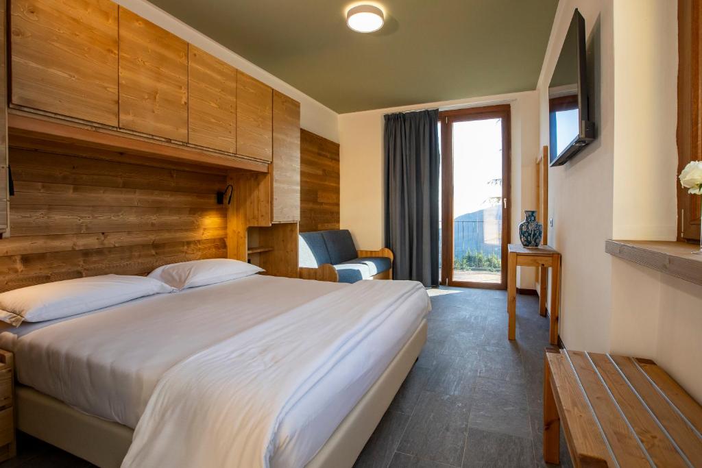 a hotel room with a large bed and a window at Chalet Bellavista in Spiazzi Di Caprino