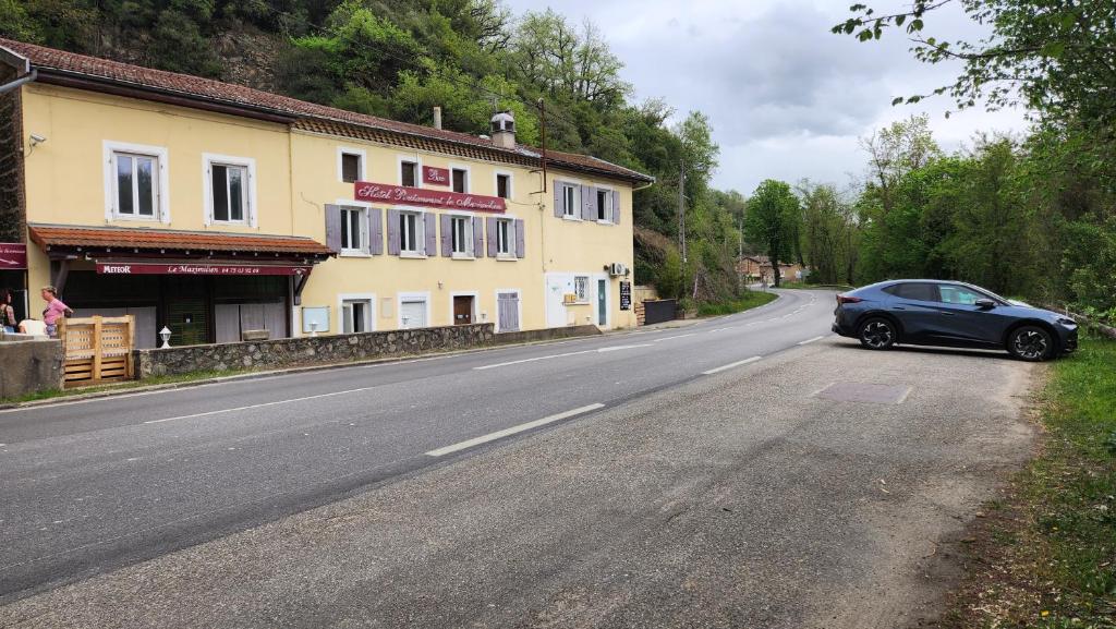 a car parked on the side of a road at Appartement refait dans ancien hôtel restaurant in Saint-Uze