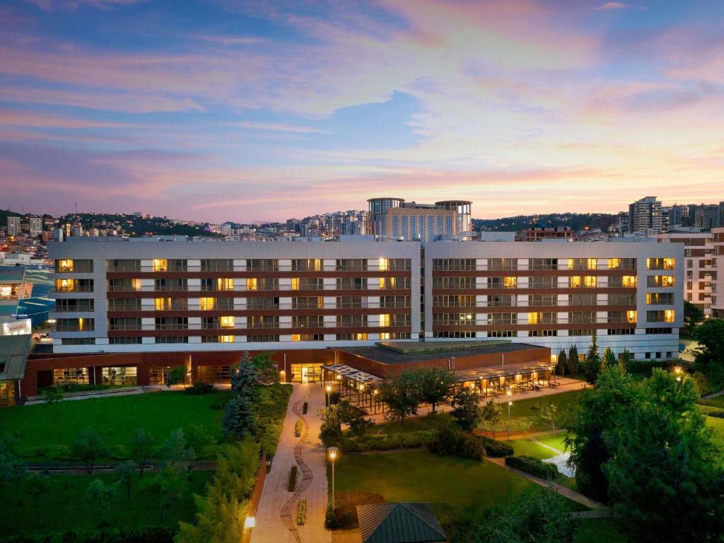a large building with lights on in a city at Novotel Trabzon in Trabzon