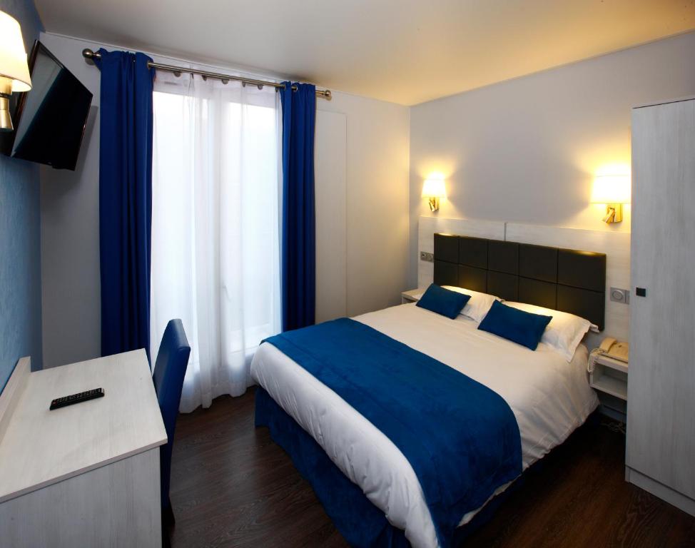 1 dormitorio con cama, escritorio y ventana en Hôtel Sunny, en París