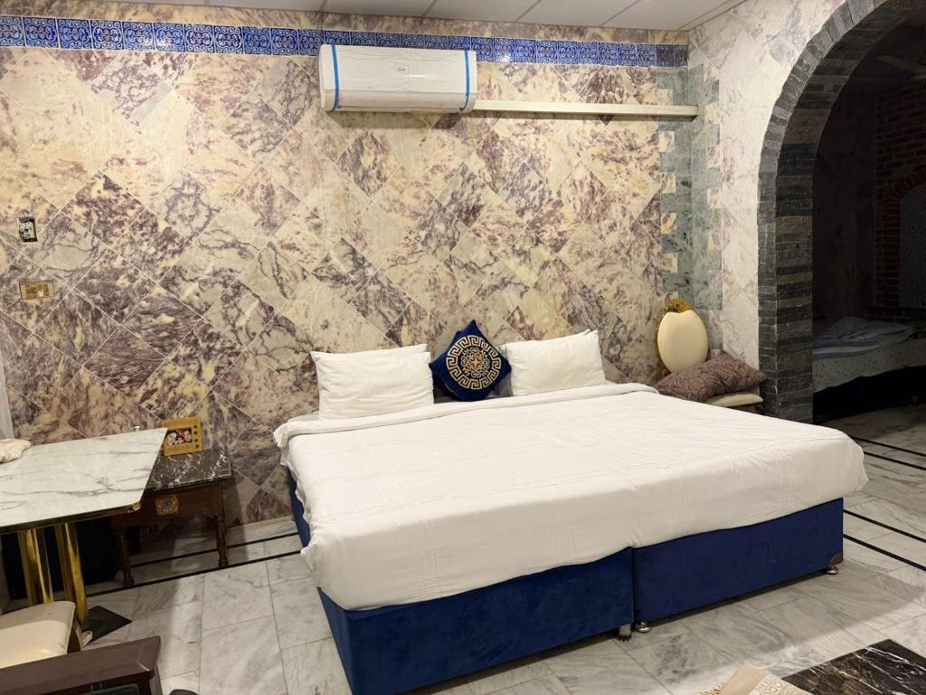 a bedroom with a large bed with a wall at Hayatt Palace Sukkur in Sukkur