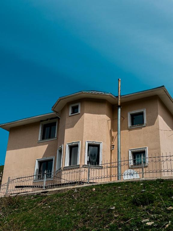 a building on top of a grassy hill at Kolsay Tanbalytas Villa in Kolʼbastau