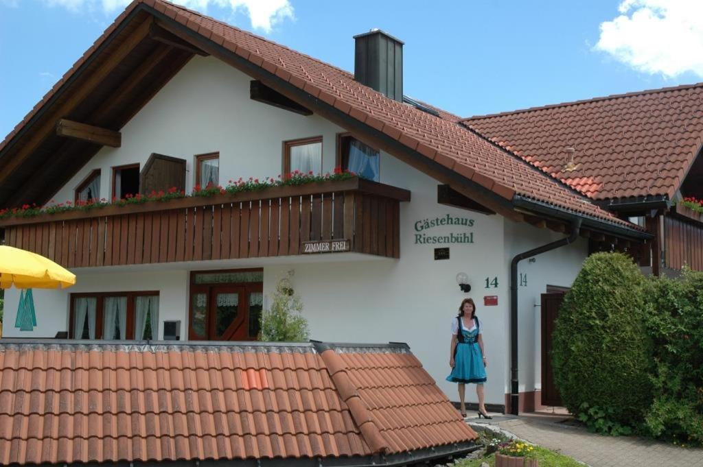 Eine Frau, die vor einem Gebäude steht. in der Unterkunft Gästehaus RIESENBÜHL in Schluchsee