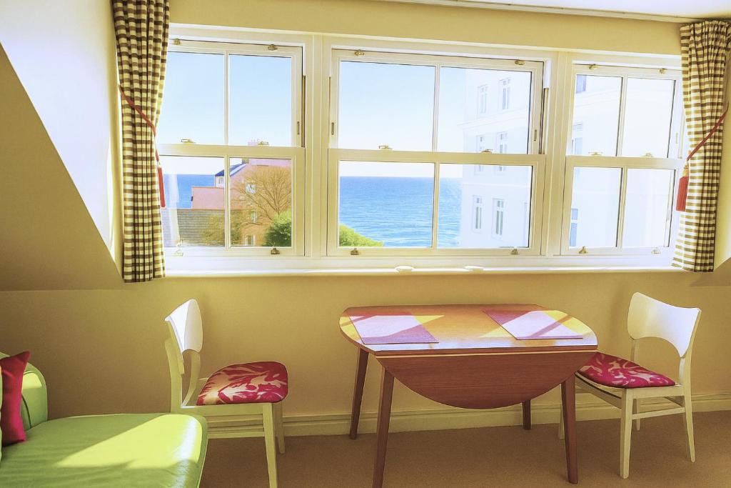 a room with a table and two chairs and a window at Spetchley House in Tenby