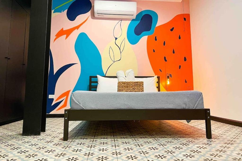 a bedroom with a bed with a painting on the wall at 5.4 Loft • Lobby • Generator • Parking • 2nd Floor in Mayaguez