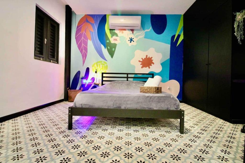 a bedroom with a bed and a colorful wall at 5.2 Loft • Lobby • Generator • Parking • 2nd Floor in Mayaguez
