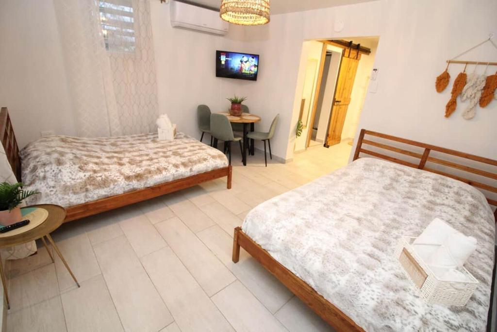 a hotel room with two beds and a table and a television at 3.9 Near Beach • Generator • Hammock • 1st Floor in Garita