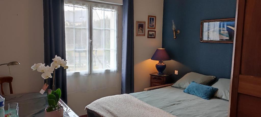 a bedroom with a bed and a window at Jolie maison d'hôtes in Changé