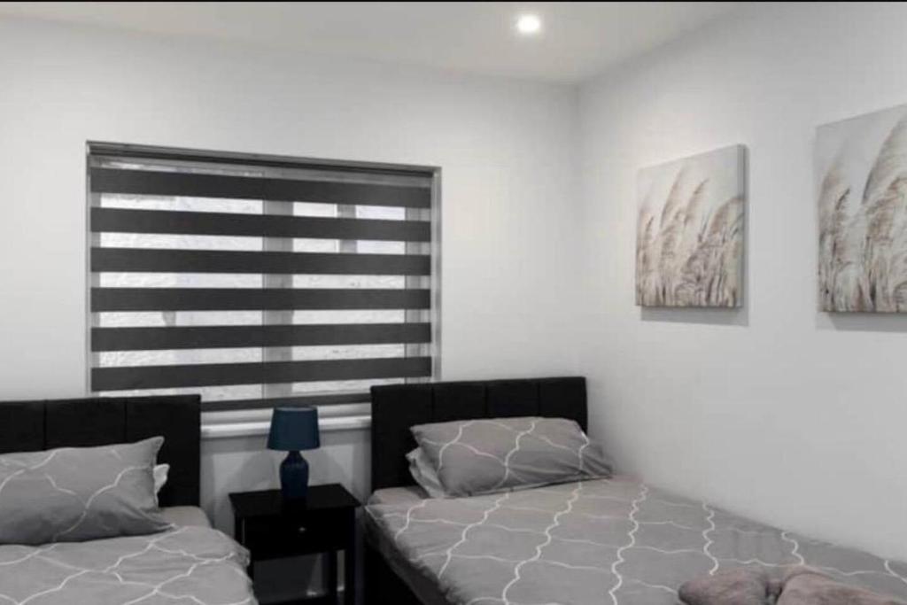 a bedroom with two beds and paintings on the wall at 3BD in Hendon in The Hyde