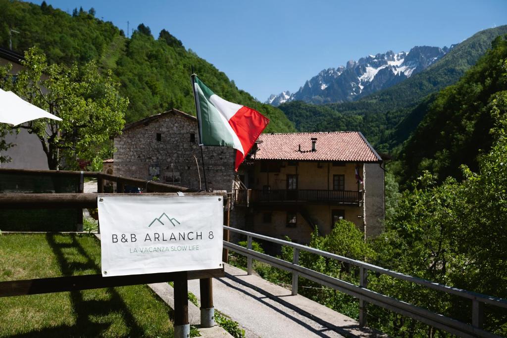 eine Flagge auf einem Schild vor einem Gebäude in der Unterkunft B&B Arlanch 8 in Vallarsa