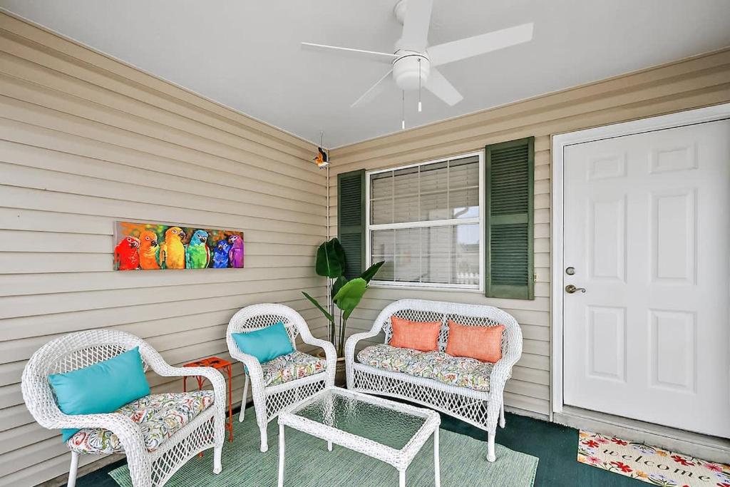 three wicker chairs and a table on a porch at Patio Villa in Santo Domingo in The Villages