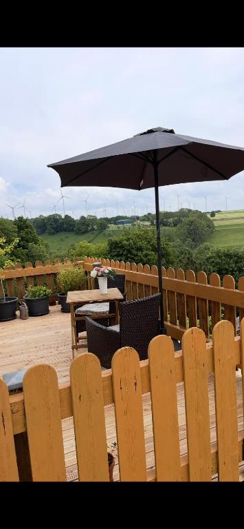 a patio with an umbrella and a table and chairs at Die Ferienwohnung im Grünen in Lichtenau