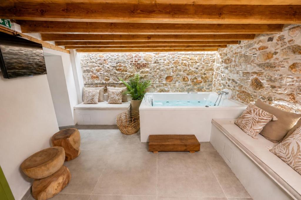 a bathroom with a tub in a stone wall at Casa Di Nonno-Jacuzzi Mountain View Stay in Lesvos in Agiásos