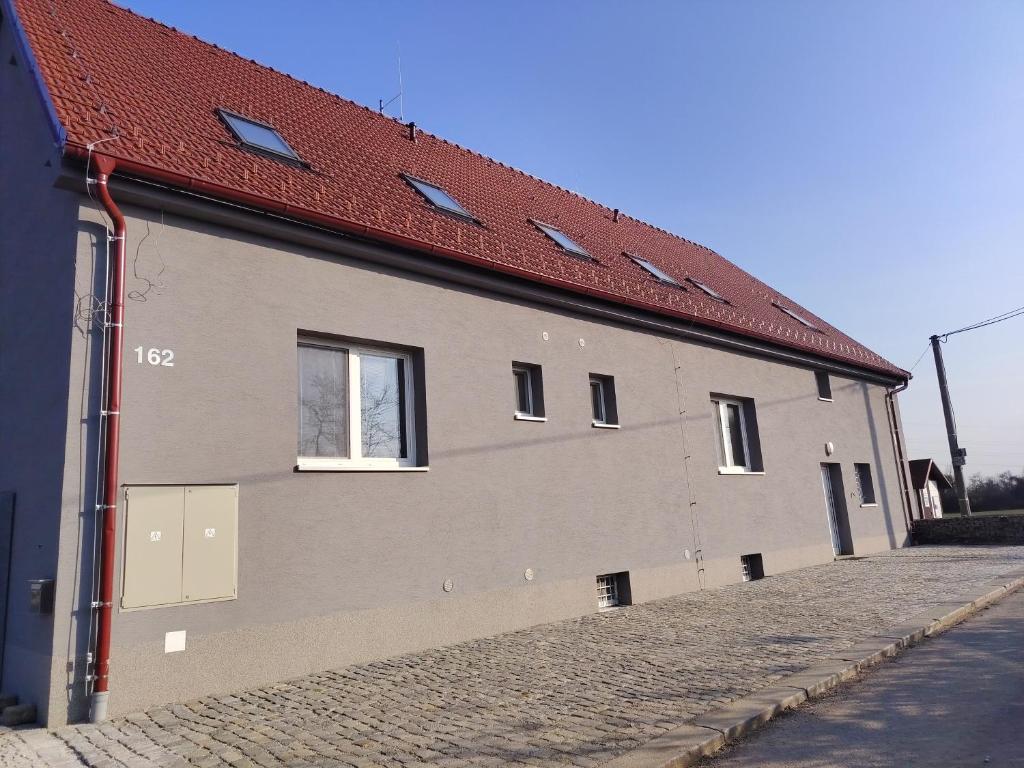 a building with a red roof on a street at Ubytování Blažej in Týnec