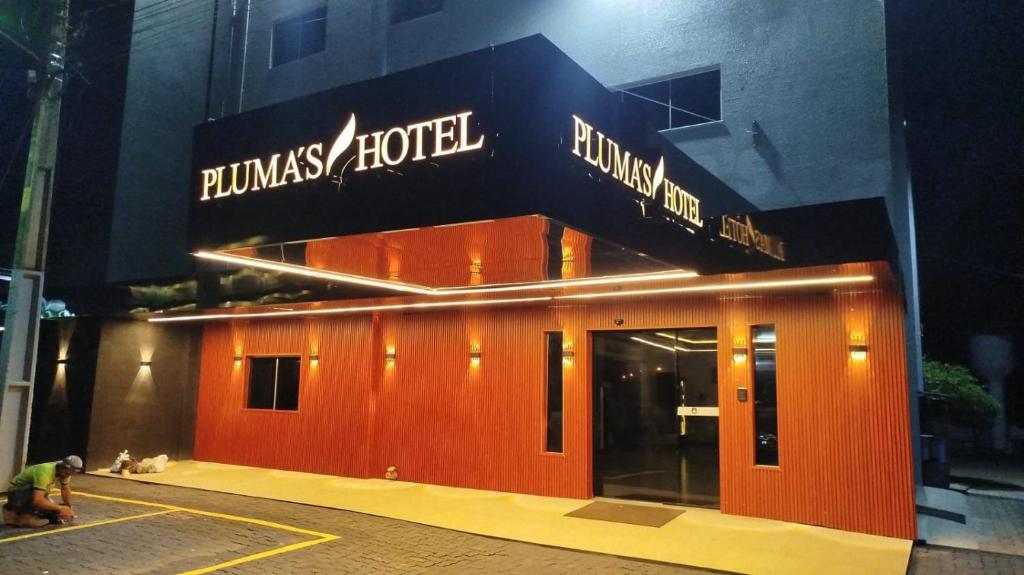 a building with a red front of a hotel at Plumas hotel in Tucuma