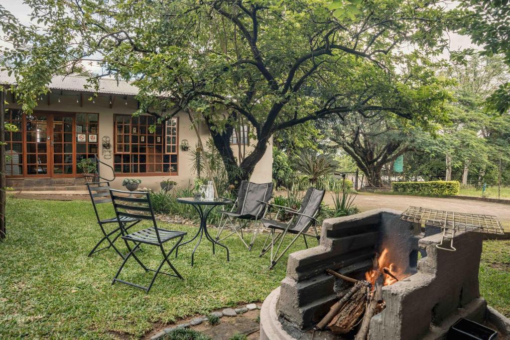 a fire pit in a yard with chairs and a table at Home on a Hill Accommodation in Tzaneen