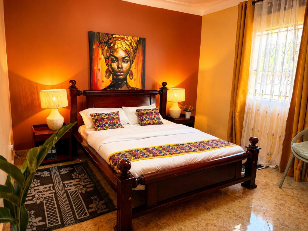a bedroom with a bed with a painting on the wall at Palm Star Motel in Fort Portal