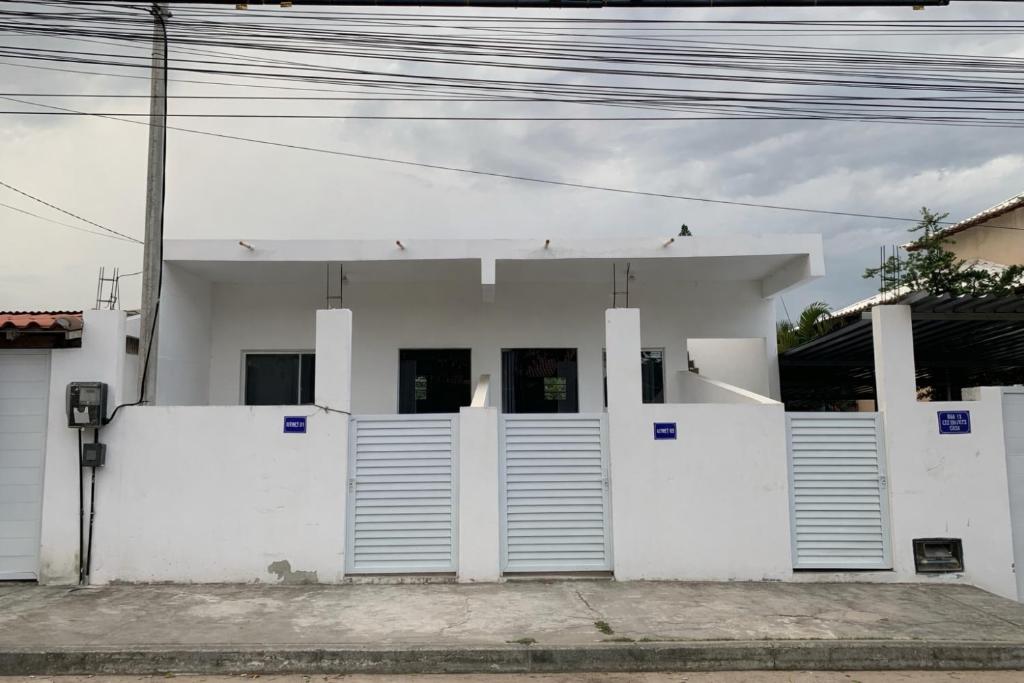 a white building with blue numbers on the doors at Kitnet Céu e mar Saquarema in Saquarema