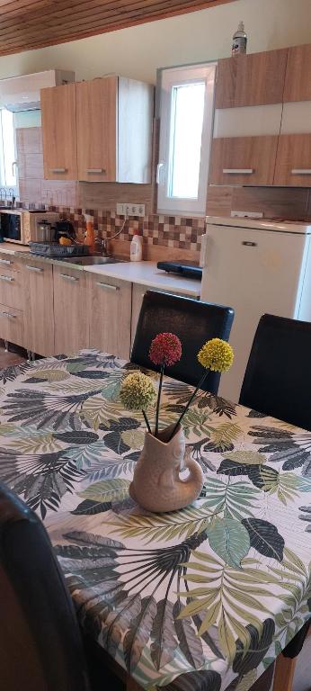 a kitchen with a table with a vase of flowers on it at Maróni Ház in Zalakaros