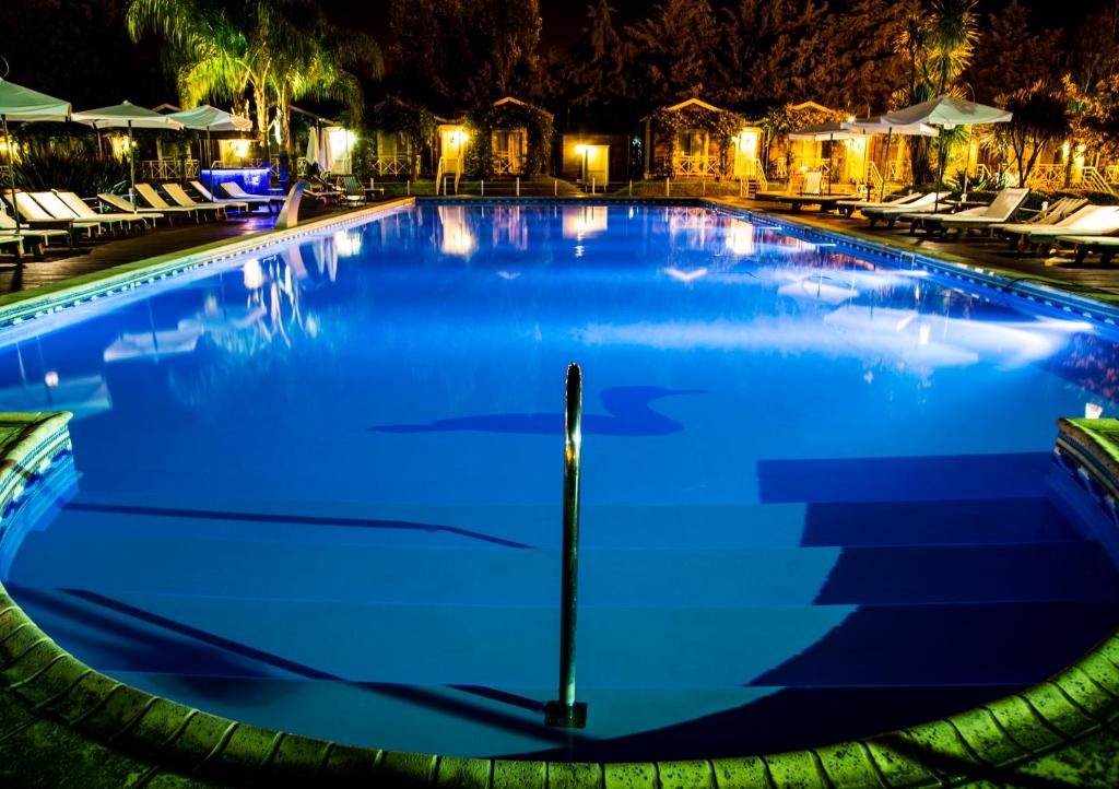 a large swimming pool at night with chairs at Hotel Spa Posada del Puerto in Gualeguaychú