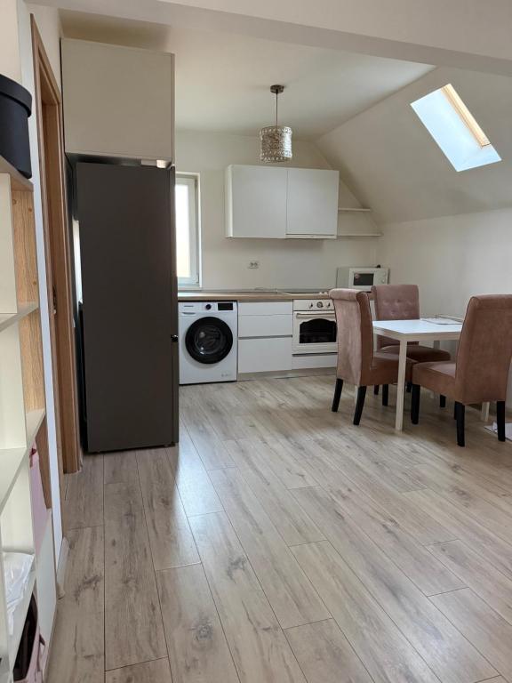 a kitchen with a table and a black refrigerator at Vanessa Home in Floreşti