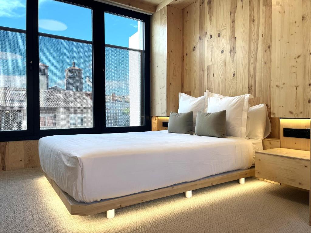 a bedroom with a large bed with a large window at VTZ Minimal Suites in Zaragoza