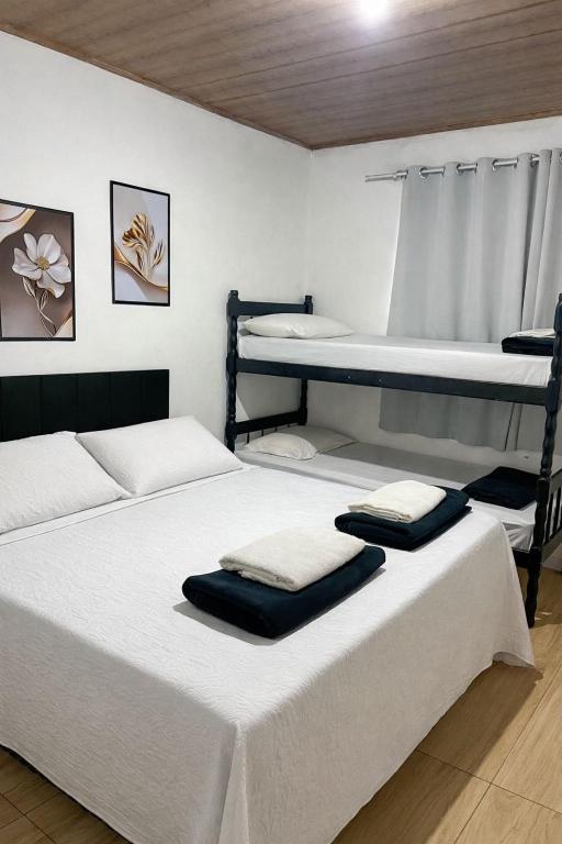 two beds in a room with two bunk beds at Hospedagem Doce lar in Joinville