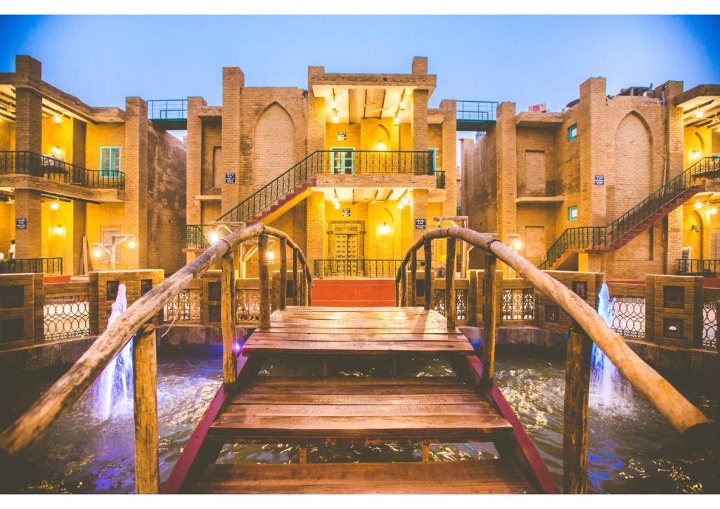uma ponte de madeira que leva a um edifício com uma escada em WelcomHeritage Ranjitvilas em Amritsar