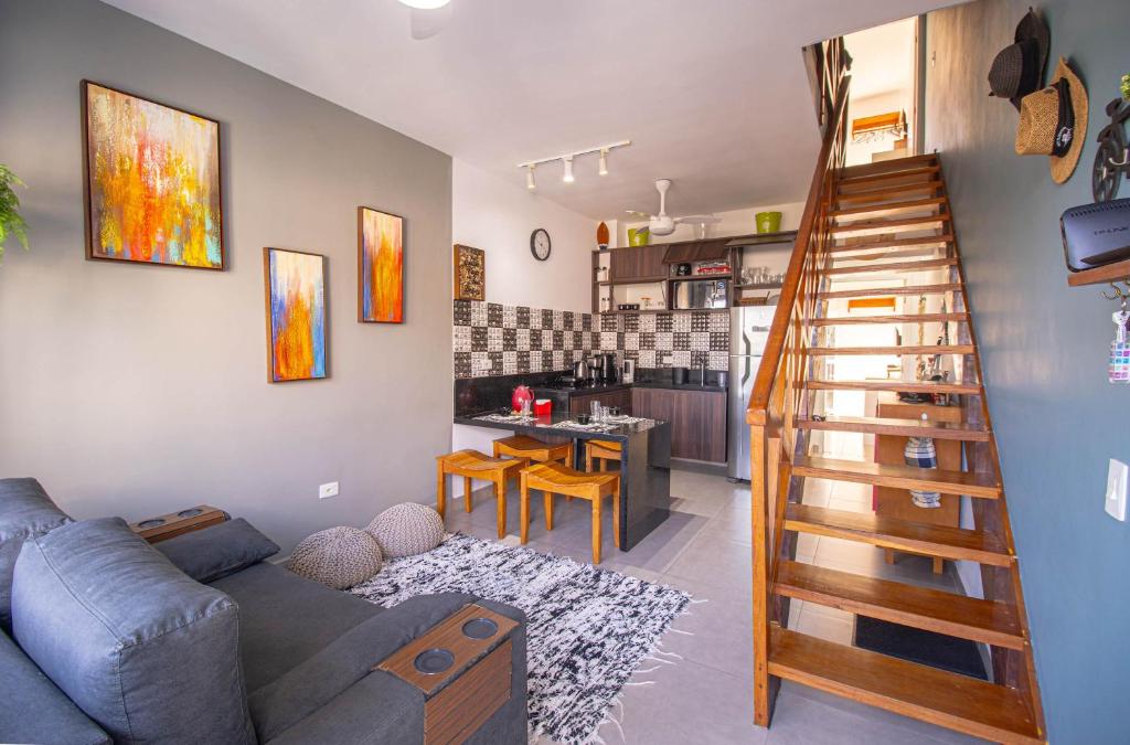a living room with a staircase leading to a kitchen at Apto Novo Duplex em Juqhey in Juquei