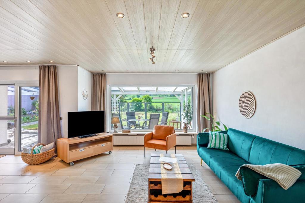 a living room with a blue couch and a tv at Zipper Burgblick Otzberg Odenwald in Hering