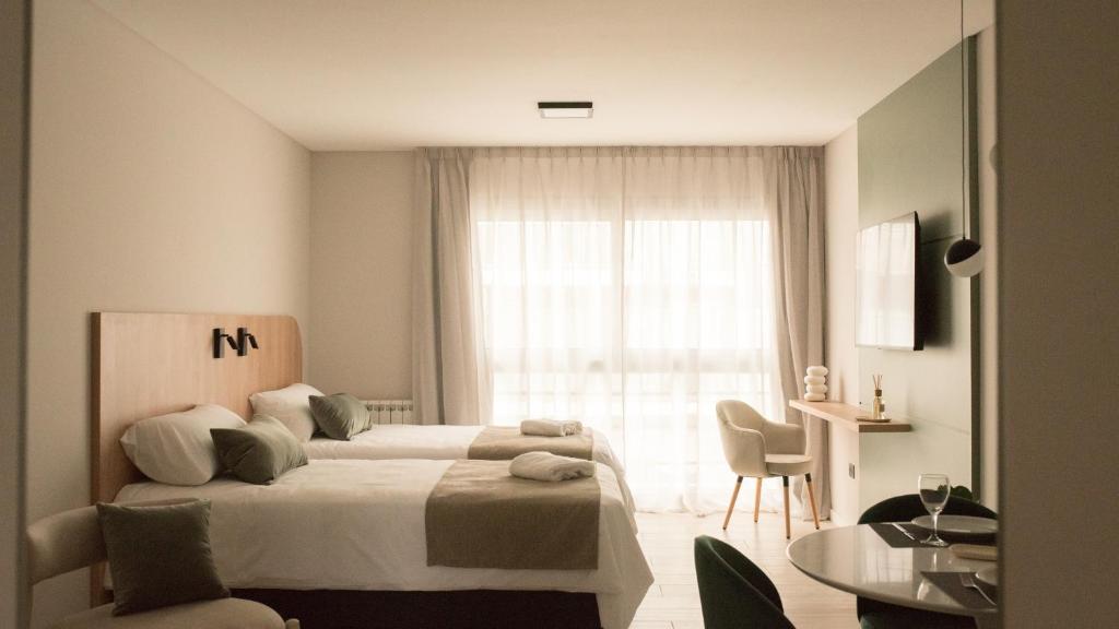 a bedroom with a bed and a table and a window at VAYU LuxuryLofts in Bahía Blanca