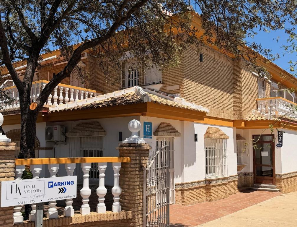a house with a sign in front of it at Hotel Victoria Matalascañas in Matalascañas