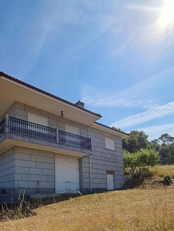 a building with a balcony on the side of it at A Morada do Cuco in Piñor