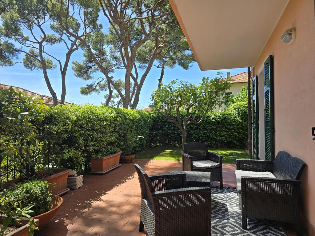 a patio with chairs and tables and trees at Casa Limone by Affitti Brevi Liguria in Borgio Verezzi