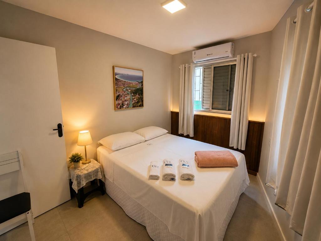 a bedroom with a large white bed with a window at GH Canal da Barra in Florianópolis