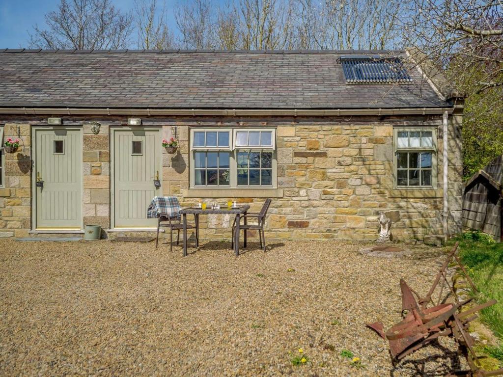 a stone cottage with a table and chairs in front of it at 1 Bed in Hexham oc-82472 in Hexham