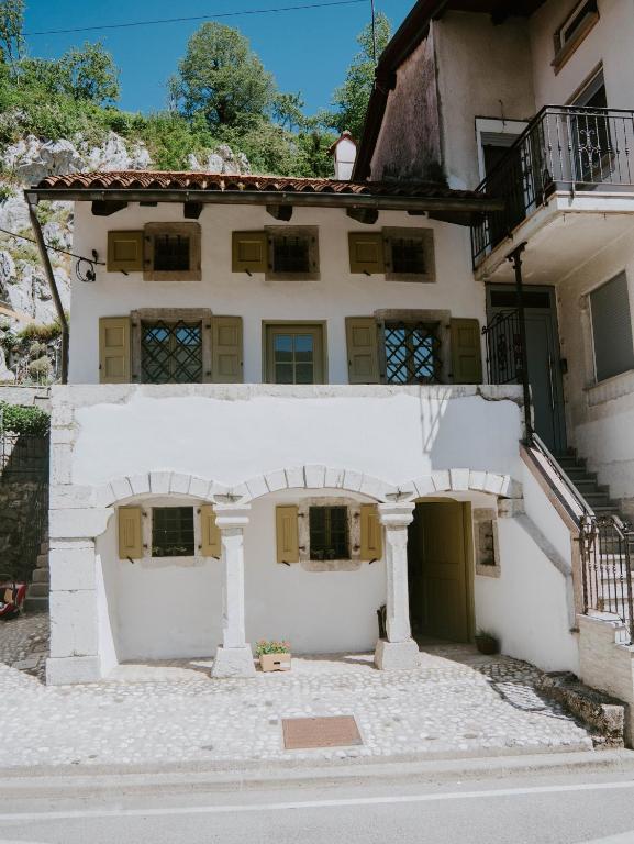 an old white house with a staircase in front of it at Hiša Liza in Kobarid