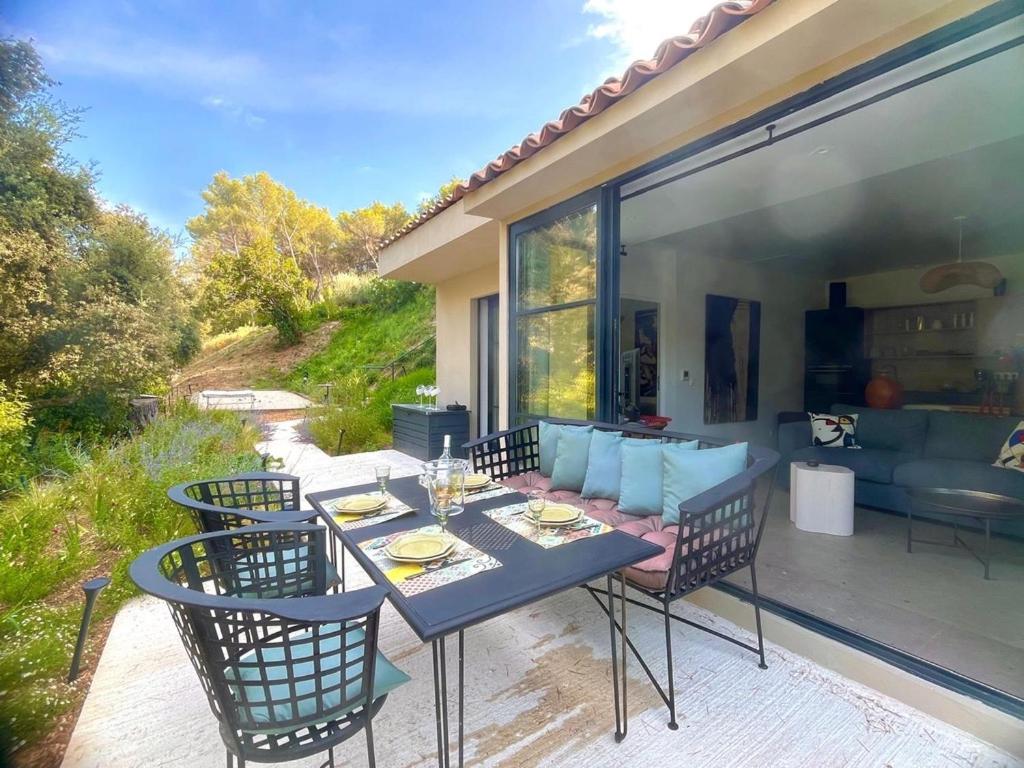 a patio with a table and chairs and a couch at Villa Toscane in Meyreuil