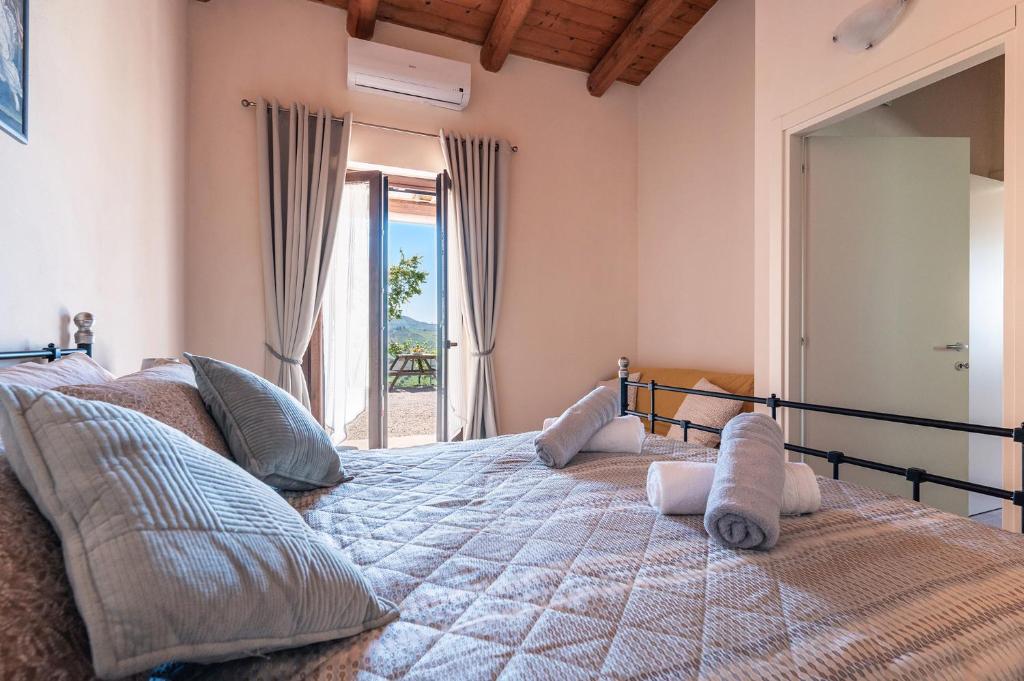 a bedroom with a large bed with a balcony at PinetoAlba Country House in Scerne