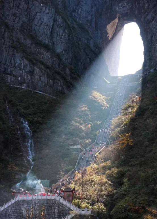 a train going through a tunnel in a mountain at Sky Gate Guesthouse-English Speaking Hostess, Family friendly,2-minute walk to Entrance of Tianmen Mount ,Free pick up service,Book attraction tickets, Free Laundry,Private Tour in Zhangjiajie