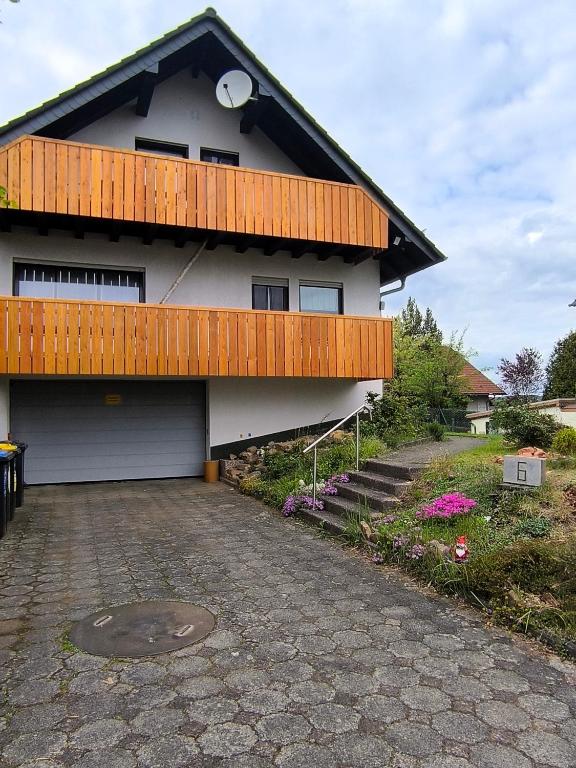 a house with a porch and a driveway at Ferienwohnung am Riedrain in Eichenzell