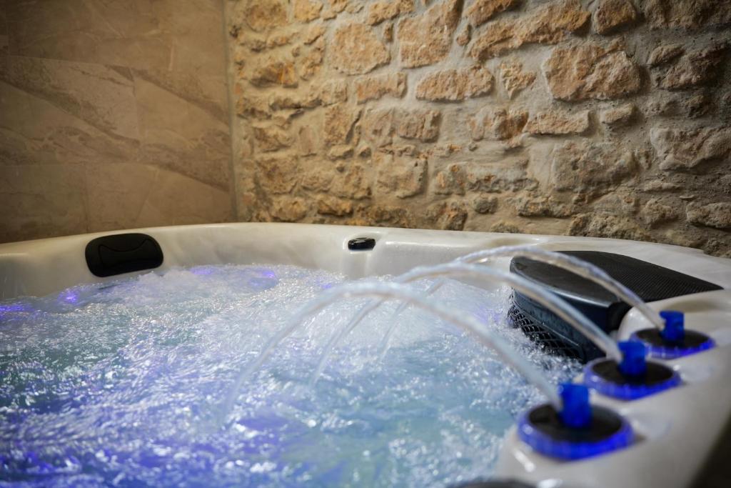 a bath tub with water coming out of it at La maison des Bretzels GÎTE Jacuzzi privé illimité in Pfaffenhoffen