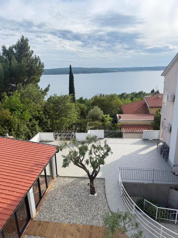 a view of the water from a house with a tree at Apartments Luna in Dramalj