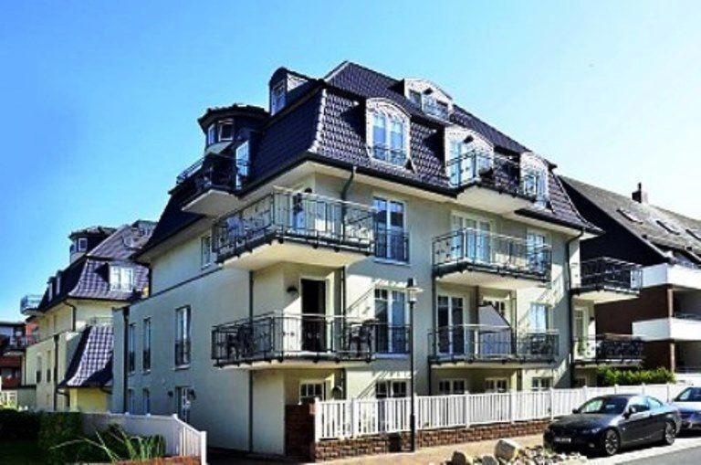 a large white building with balconies and a car at Ferienwohnung-Silvie-8 in Westerland